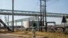 FILE - A miner walks past the entrance of the Sibanye-Stillwater platinum mine in Marikana, South Africa, on May 15, 2020. 