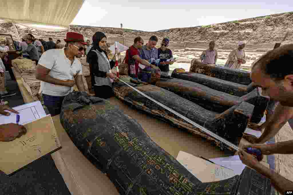 Archaeologists measure the length to register one of the sarcophaguses found in a cache dating to the Egyptian Late Period (around the fifth century B.C.), discovered by a mission headed by Egypt&#39;s Supreme Council of Antiquities, at the Saqqara necropolis, southwest of Egypt&#39;s capital.
