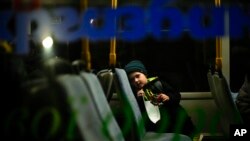 A child who fled from Mariupol with his family waits in a bus upon their arrival at a reception center for displaced people in Zaporizhzhia, Ukraine, May 8, 2022.