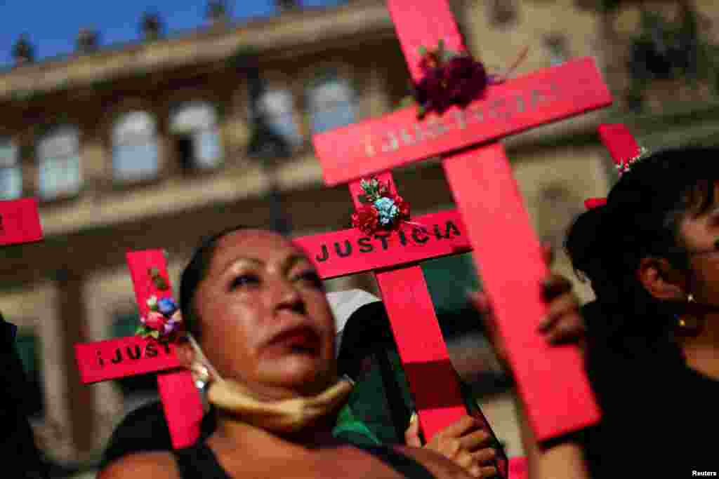 Mujeres sostienen cruces en una protesta contra el feminicidio y la violencia contra las mujeres frente al Palacio Nacional en la Ciudad de México.&nbsp;