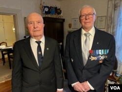 Unto Hakuli, 99, at left, and Tapio Niemi, 94, pose in Niemi's family home in Taipalsaari, Finland, around 30 kilometers from the Russian border, May 2, 2022. (Henry Ridgwell/VOA)