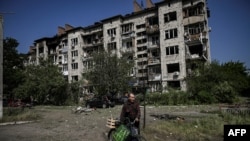 An eldery man walks by a damaged appartment building after a strike in the city of Slovyansk at the eastern Ukrainian region of Donbas on May 31, 2022.