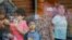 Los niños miran a través de una ventana de vidrio desde el interior del Centro Cívico Ssgt Willie de Leon, a donde fueron transportados desde la Escuela Primaria Robb después de un tiroteo, en Uvalde, Texas, el 24 de mayo de 2022.