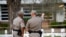 Texas Department of Public Safety officers stand in front of a memorial outside Robb Elementary school, after a gunman killed nineteen children and two teachers, in Uvalde, Texas, May 26, 2022.