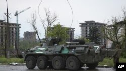 俄罗斯扶持的顿涅茨克人民共和国的民兵及装甲车守在马里乌波尔的亚速钢铁厂附近。(2022年5月19日) 
