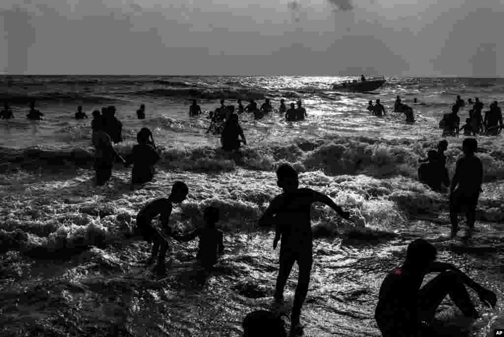 Children play at a crowded Juhu beach on the Arabian Sea coast on a hot and humid day in Mumbai, India.