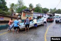 Los pescadores trasladan un bote a un terreno más alto mientras el huracán Agatha avanzaba hacia la costa sur de México, en Puerto Escondido, estado de Oaxaca, México, 30 de mayo de 2022.