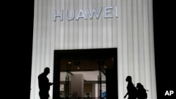 Sejumlah pembeli tampak berjalan melewati sebuah toko Huawei di Beijing, China, pada 26 Agustus 2021. (Foto: AP/Ng Han Guan)