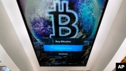 In this Feb. 9, 2021, file photo, the Bitcoin logo appears on the display screen of a cryptocurrency ATM at a store in Salem, N.H. (AP Photo/Charles Krupa, File)