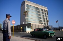 En esta foto tomada el 3 de mayo de 2022, un oficial de la policía hace guardia frente a la embajada de Estados Unidos en La Habana, mientras el consulado reanudaba la emisión de algunos servicios de visas de inmigrantes que habían estado suspendidos desde 2017.