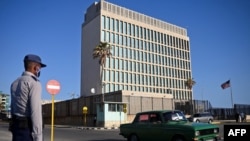 En esta foto de archivo tomada el 3 de mayo de 2022, un oficial de policía hace guardia frente a la embajada de Estados Unidos en La Habana, el día que el consulado reanudó la emisión de algunos servicios de visas de inmigrantes que habían sido suspendidos desde 2017.