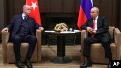 FILE - In this Sept. 29, 2021, file photo, Russian President Vladimir Putin, right, and Turkish President Recep Tayyip Erdogan talk during their meeting in the Bocharov Ruchei residence in the Black Sea resort of Sochi, Russia.