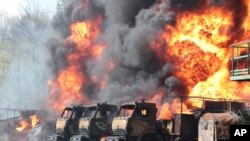 Sejumlah kendaraan yang terparkir pada depot minyak di Makiivka, yang terletak 15 kilometer di timur Kota Donetsk, Ukraina, terbakar setelah sebuah misil menyerang tempat tersebut 4 Mei 2022. (Foto: AP)