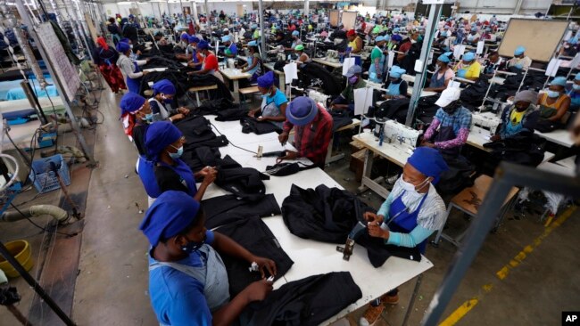 FILE - Workers tend to their jobs in a garment factory in Maseru, Lesotho, Feb. 24, 2022. The coronavirus pandemic impacted the global fashion industry and the tens of millions of workers, most of them women, who stitched the world's clothes.