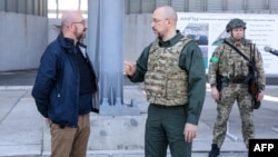A handout picture, taken and released by Ukrainian Prime Minister Press Service on May 9, 2022, shows European Council President Charles Michel (left) listening to Ukraine's Prime Minister Denys Shmyhal during their meeting in the southern Ukrainian port.