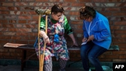 Social worker Zhanna Protsenko (right) speaks with Nyna Provontsova, in Orikhiv, near Zaporizhzhia, eastern Ukraine, on May 11, 2022.