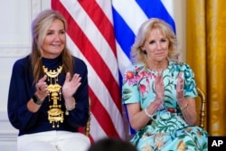 Mareva Grabowski, wife of Greek Prime Minister Kyriakos Mitsotakis, and first lady Jill Biden applaud during a reception with President Joe Biden in the East Room of the White House in Washington, May 16, 2022.