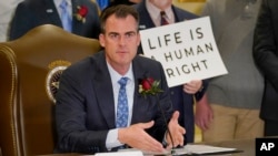 FILE - In this April 12, 2022, file photo, Oklahoma Gov. Kevin Stitt speaks after signing into law a bill making it a felony to perform an abortion, punishable by up to 10 years in prison in Oklahoma City.