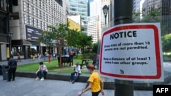 FILE - A notice on restrictions on the size of groups to stop the spread of the Covid-19 coronavirus is pictured on a lamp post in Singapore on March 29, 2022. (Photo by Roslan RAHMAN / AFP)