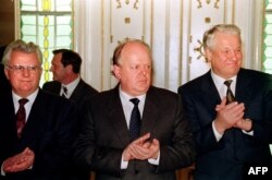 FILE - Stanislav Shushkevich of Belarus, center, Leonid Kravchuk of Ukraine, left, and Boris Yeltsin of Russia, applaud after signing a document that dissolved the Soviet Union on December 8, 1991.