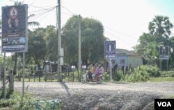 Signs of Cambodia People's Party are seen in between that of the Candlelight Party, along National Road 5, in Kampong Chhnang province, on May 05, 2022. (Khan Sokummono/VOA Khmer)