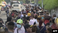 Familiares de hombres con presuntos vínculos con pandillas capturados por la Policía Nacional Civil y el ejército salvadoreño durante el estado de emergencia esperan información afuera de la prisión La Esperanza en San Salvador, el 17 de mayo de 2022.