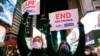 资料照片：2022年1月18日，人们在纽约时报广场举着支持亚裔太平洋岛民社区的标语，参加纪念地铁袭击事件受害者米歇尔·阿丽莎·戈 (Michelle Alyssa Go) 的烛光守夜活动。（美联社照片）