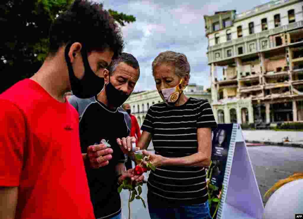 Una mujer enciende una vela durante una vigilia por las víctimas del accidente del Hotel Saratoga en La Habana, el 13 de mayo de 2022.