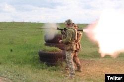 Ukrainian troops use a foreign-made anti-tank grenade launcher in this photo tweeted by the Ukrainian defense ministry on May 7, 2022.