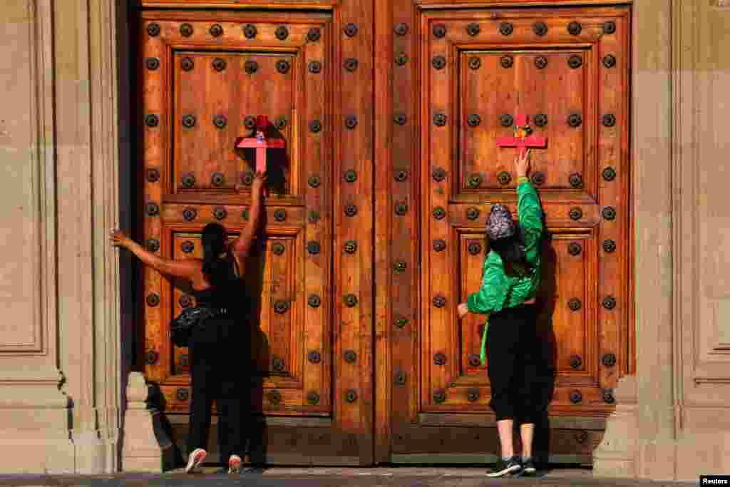 Mujeres colocan cruces en las puertas de Palacio Nacional, en la Ciudad de México, la capital del país.&nbsp;
