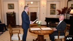 Australia's new Prime Minister Anthony Albanese (L) takes an oath in front of Australia's Governor General David Hurley (R) at Government House in Canberra on May 23, 2022.