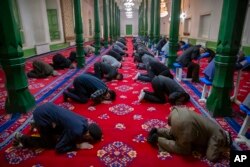 FILE - Uyghurs pray at the Id Kah Mosque in Kashgar in western China's Xinjiang Uyghur Autonomous Region. Allegations of human rights abuses in Xinjiang region are expected to be the dominant issue during the visit to China by the U.N. High Commissioner for Human Rights Michelle Bachelet.