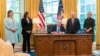 Predsednik SAD Džo Bajden potpisuje zakon o pomoći Ukrajini okružen članovima Kongresa, u Ovalnom kabinetu, u Beloj kući, 9. maja 2022.