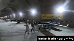이란 모처에서 군복을 입은 사람들이 드론(무인 비행기)을 가리키며 대화하고 있다. (자료사진)
