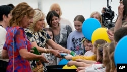 First lady Jill Biden and first lady of Romania Carmen Iohannis greet people during their visit to a school in Bucharest Romania, May 7, 2022, to meet students and the educators who are teaching displaced Ukrainian children.
