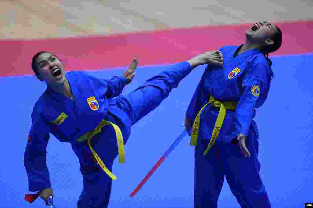 Cambodia&#39;s Pov Sokha and Soeur Chanleakhena compete in the female pair sword form category of the vovinam event during the 31st Southeast Asian Games (SEA Games) in Hanoi.