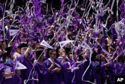 FILE - Confetti drops on graduates as they celebrate at Yankee Stadium on May 18, 2022. (AP Photo/Seth Wenig)