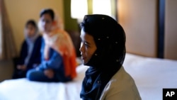 FILE - Gulsom Esmaelzade, 35, right, sits with her sisters, Shoriya, 34, left, and Susan, 28, in a hotel room where Susan sleeps, May 4, 2022, in San Diego. The family has been shuttled among hotel rooms in the San Diego area since January, after spending three months at a New Jersey military base. "We don't have anything back at home in Afghanistan and here we also don't have any future," said Gulsom.