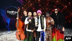 Eurovision ဂီတပြိုင်ပွဲမှာ အနိုင်ရခဲ့တဲ့ "Kalush Orchestra" အဖွဲ့နဲ့ ယူကရိန်းစစ်တပ်အတွက် ရံပုံငွေရဖို့ လေလံပစ်ခဲ့တဲ့ သူတို့ရဲ့ မိုက်ရိုဖုန်းသလင်းကျောက်ဆု။ (မေ ၁၄၊ ၂၀၂၂)