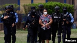 Agentes de la policía hondureña escoltan a Herlinda Bobadilla, acusada de liderar un cartel del narcotráfico, en Tegucigalpa, Honduras, 15 de mayo de 2022. Foto Reuters.