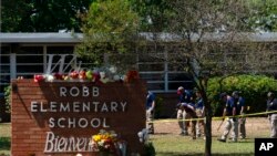 Hetuesit duke kërkuar për evidencë përreth shkollës fillore Robb, në Uvalde të Teksasit (25 maj 2022)