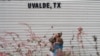 Seorang perempuan menangis dan memeluk seorang anak ketika berada di luar Gedung Willie de Leon Civic, tempat di mana pelayanan konseling diberikan bagi para keluarga korban penembakan sebuah sekolah dasar di Uvalde, Texas, pada 24 Mei 2022. (Foto: AFP/Allison Dinner)