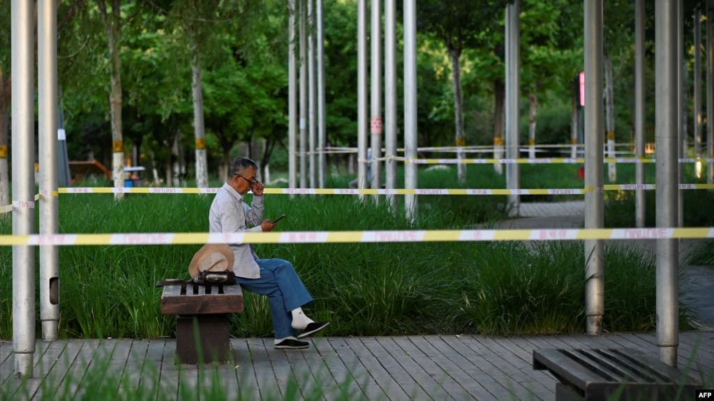 2022年5月27日，新冠疫情期间，北京一名老人在隔离区内使用手机。(法新社）(photo:VOA)