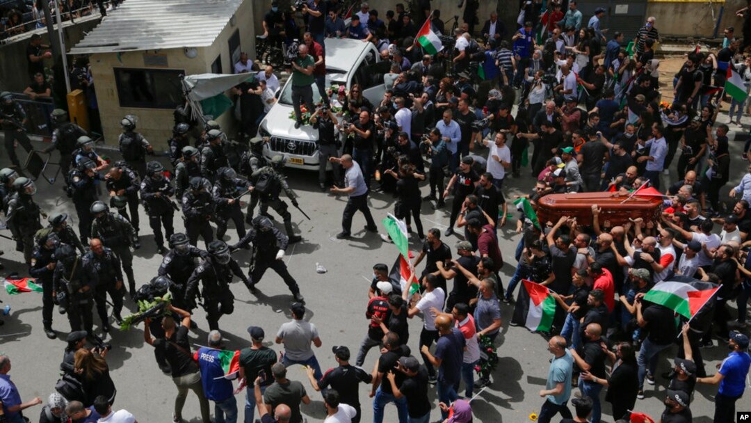 Israeli police confront mourners carrying the casket of slain Al Jazeera journalist Shireen Abu Akleh during her funeral in east Jerusalem, May 13, 2022. 