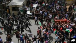 Israeli police confront mourners carrying the casket of slain Al Jazeera journalist Shireen Abu Akleh during her funeral in east Jerusalem, May 13, 2022. 