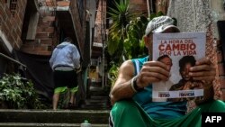 Un hombre lee propaganda política del candidato presidencial colombiano Gustavo Petro de la coalición de izquierda Pacto Histórico, en el barrio Comuna 13, en Medellín, Colombia, el 27 de mayo de 2022.