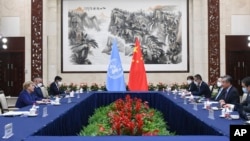 FILE - In this photo released by Xinhua News Agency, Chinese Foreign Minister Wang Yi, second right, meets with the United Nations High Commissioner for Human Rights Michelle Bachelet, left, in Guangzhou, in southern China's Guangdong province, May 23, 2022.