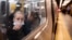 FILE - A passenger looks out onto the platform while riding a northbound train in the 36th Street subway station during the morning commute, in New York, April 13, 2022. 