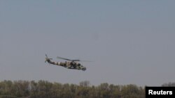 Вертоліт Збройних сил України Мі-24 летить над полем у невідомому місці на сході України, 6 травня 2022 року. REUTERS/Сергій Нужненко