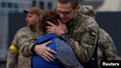 Territorial Defense Force member Dimitry hugs his girlfriend Valentine before boarding a train for the front line, amid Russia's invasion of Ukraine, in Kyiv, Ukraine, May 25, 2022. 